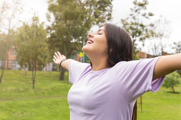 Young woman calmly opening her arms in the park