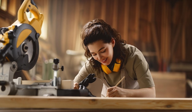 Young woman carpenter is working in a workshop