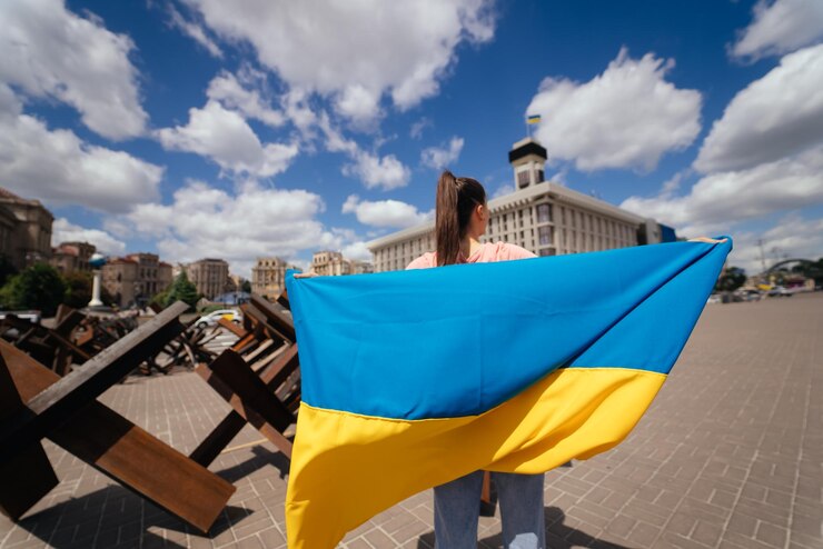 Фотография молодая женщина несет за собой развевающийся флаг украины