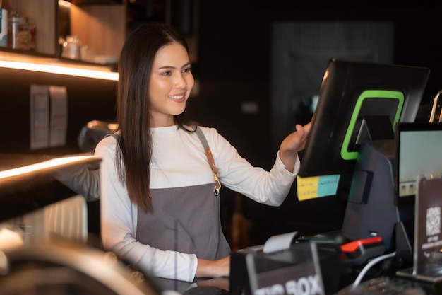 A young woman cashier working in modern coffee shop