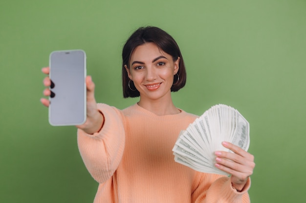 Photo young woman in casual peach sweater isolated on green olive wall