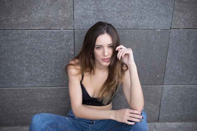 Young woman in casual wear sitting on street