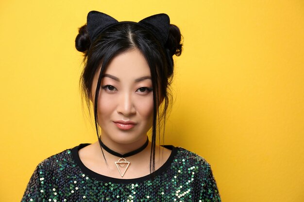 Photo young woman in cat ears on color background