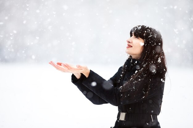 若い女性が雪をキャッチ