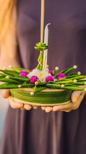 Young woman celebrates loy krathong runs on the water loy krathong festival people buy flowers and