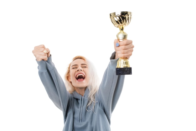 Foto una giovane donna festeggia la vittoria del concorso con una coppa d'oro su sfondo bianco