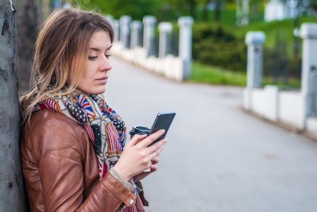 Photo young woman chatting on cell telephone with friend, female search information via network on smart phone while waiting someone