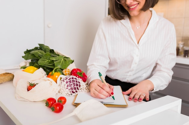 食料品のリストをチェックする若い女性