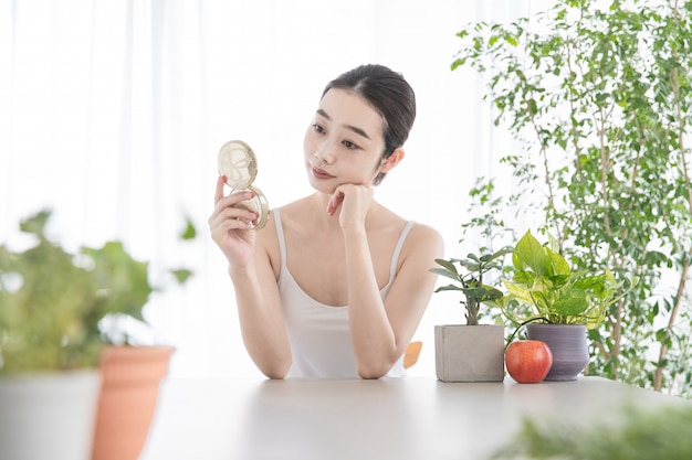 젊은여자가 그녀의 피부를 확인