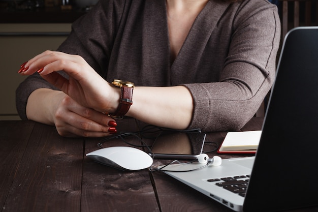 Young woman checking time on her watch