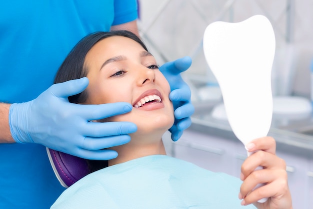 Young woman checks her teeth in the mirror