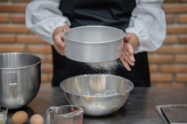 Foto cuoco unico della giovane donna che cucina dolce in cucina