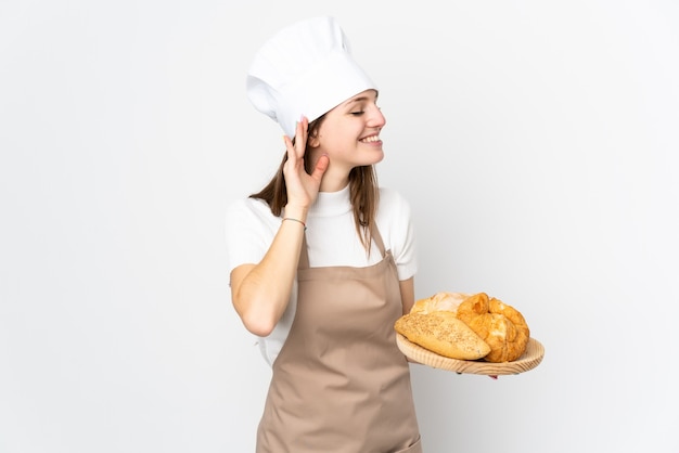 Young woman in chef uniform isolated on white listening something