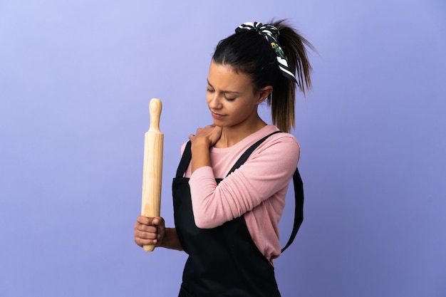 Young woman in chef uniform suffering from pain in shoulder for having made an effort