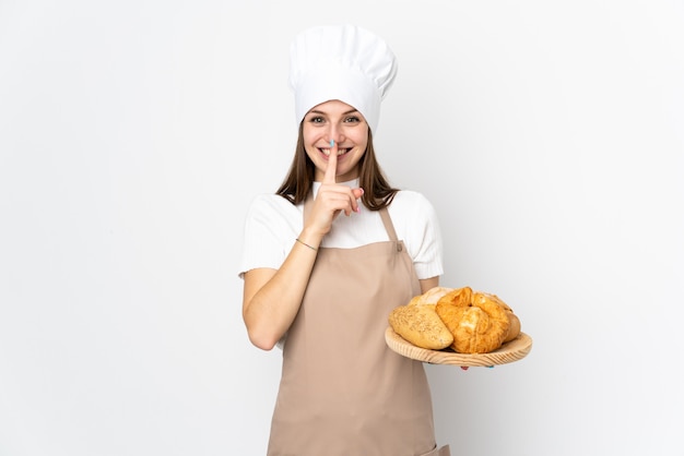 Young woman in chef uniform on white doing silence gesture