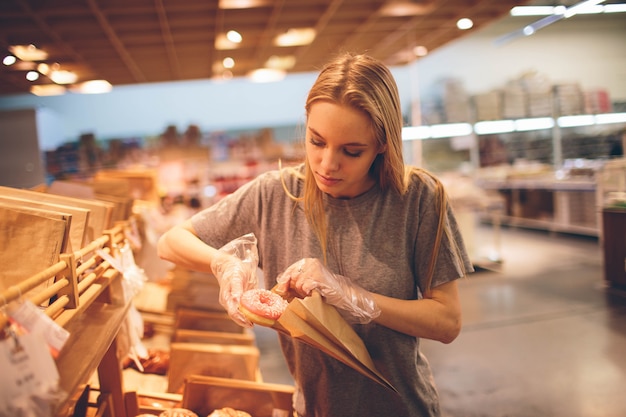 Young woman chooses bread in the store