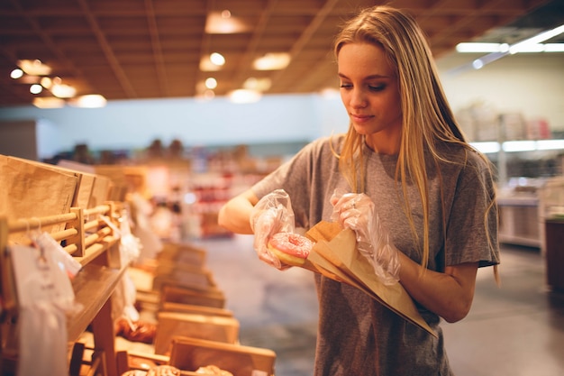 Young woman chooses bread in the store