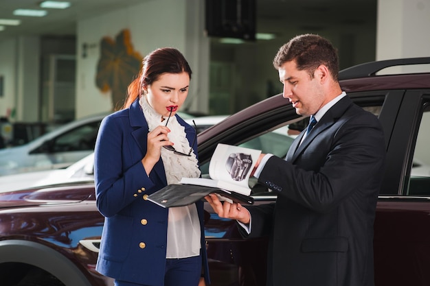 Young woman chooses an expensive SUV at the car dealership