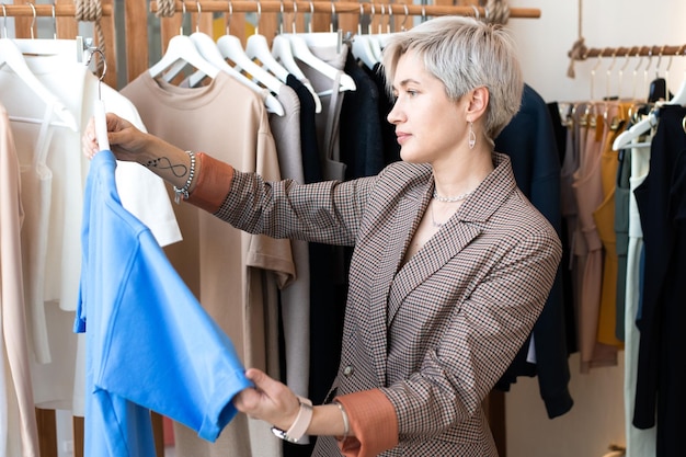 Young woman choosing clothes at store