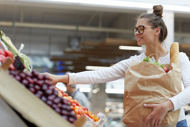 Photo young woman choosing fruits