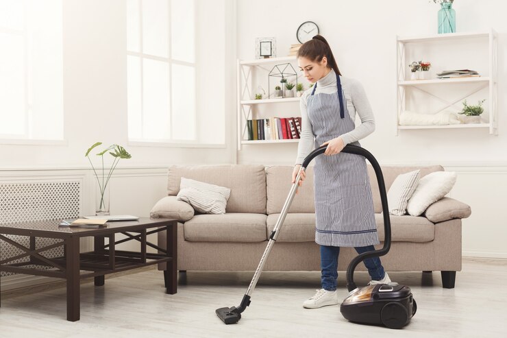 Photo young woman cleaning house with vacuum cleaner