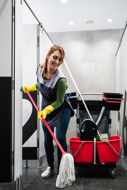 Young woman cleaning at shopping mall. Cleaning concept.