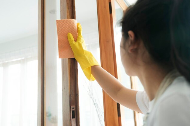 Young woman cleaning window