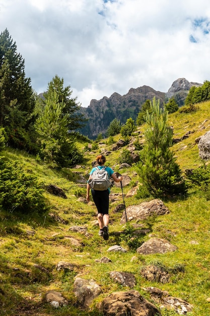 A young woman climbing the mountain to the Piedrafita arch in the Pyrenees in Panticosa Aragon