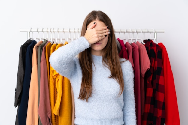 Photo young woman in a clothing store covering eyes by hands