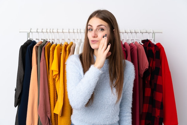 Young woman in a clothing store whispering something