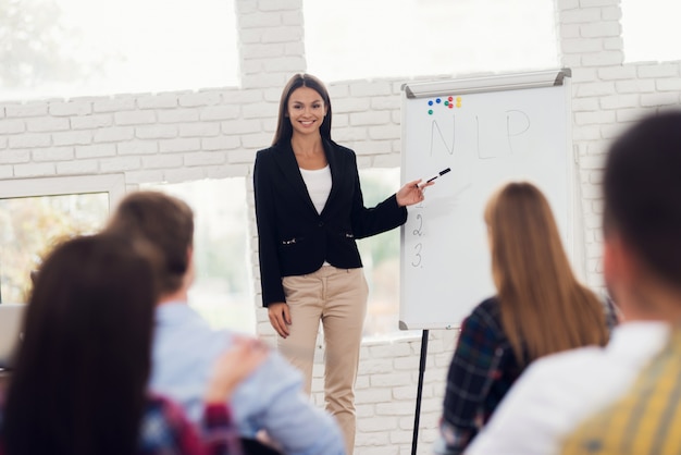 Il coacher della giovane donna sta conducendo il seminario.