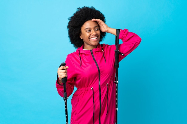 Young woman in a coat holding trekking poles