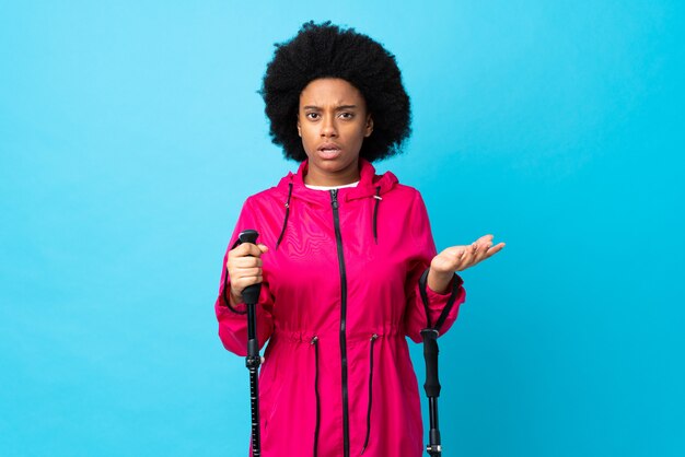 Young woman in a coat holding trekking poles