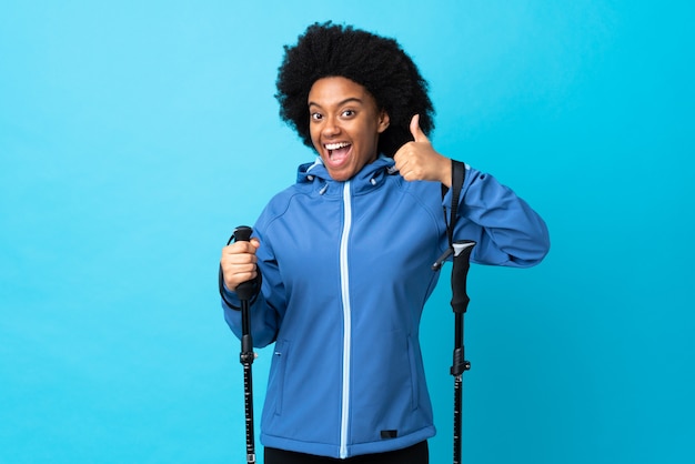 Young woman in a coat holding trekking poles