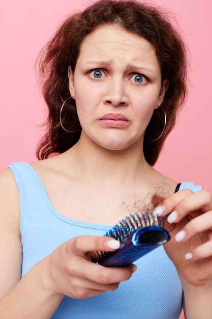 Молодая женщина расчесывает волосы отвращение к выпадению волос изолированный фон без изменений