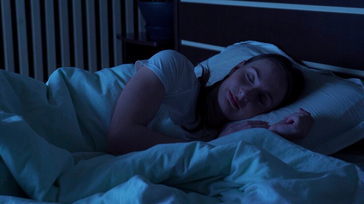 自宅のベッドで夜快適に眠っている若い女性。睡眠時間。