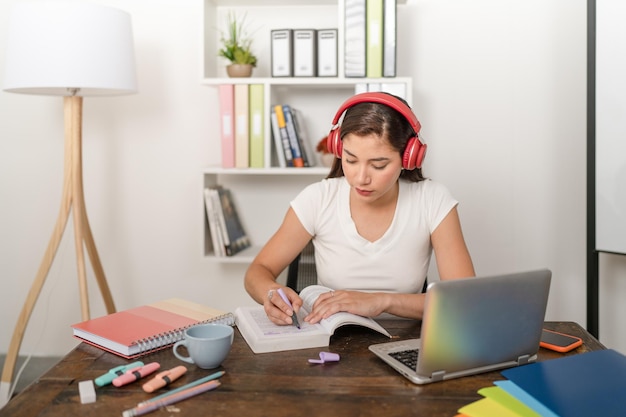 Young woman concentrating on reading and underlining a college book