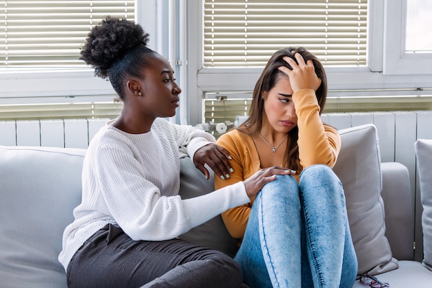 Young woman consoling her friend at home