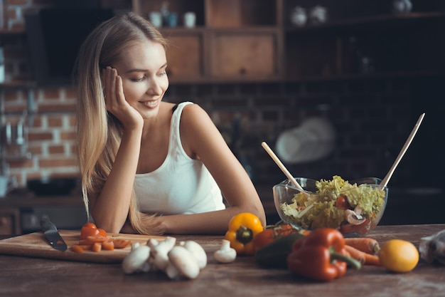 健康的な食品を調理する若い女性野菜サラダダイエットダイエットの概念家庭での健康的なライフスタイルの調理食品を準備する