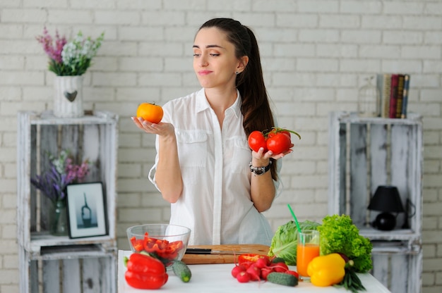 Giovane donna che cucina insalata di verdure sana