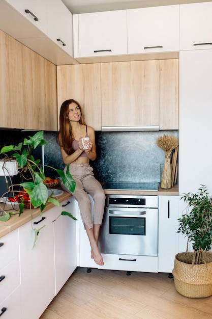 Young woman cooks in the kitchen and makes a picnic at home Vegan during quarantine Indoor plants