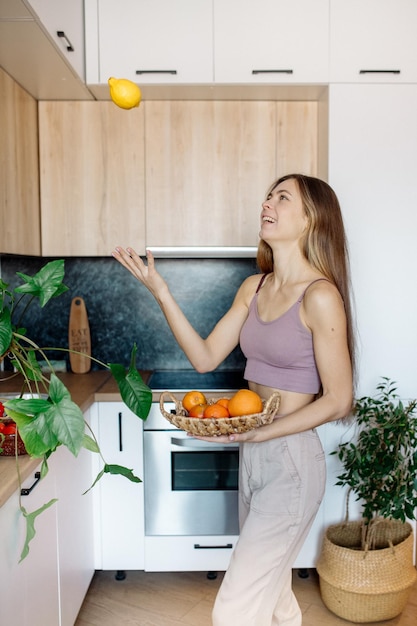 若い女性は台所で料理をし、家でピクニックをします屋内植物の検疫中にビーガン