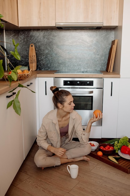 若い女性は台所で料理をし、家でピクニックをします屋内植物の検疫中にビーガン