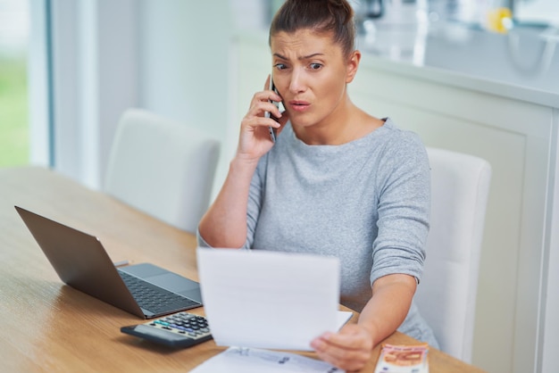 Young woman counting home budget with bills