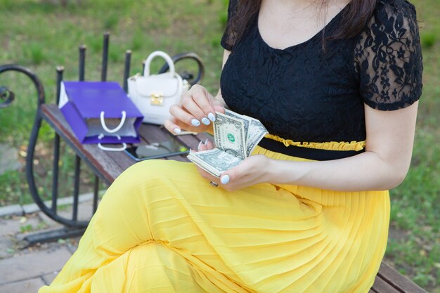 Young woman counting money in the park