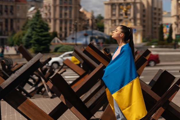 Foto giovane donna coperta con la bandiera ucraina