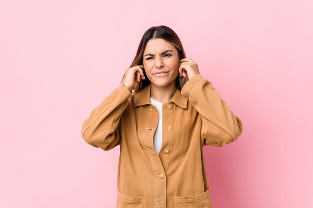 Young woman covering ears with hands