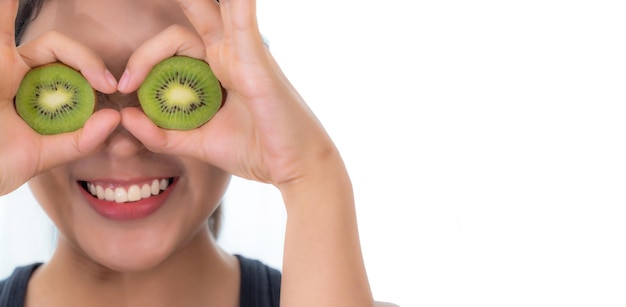 Photo young woman covering eyes with kiwi slices against white background