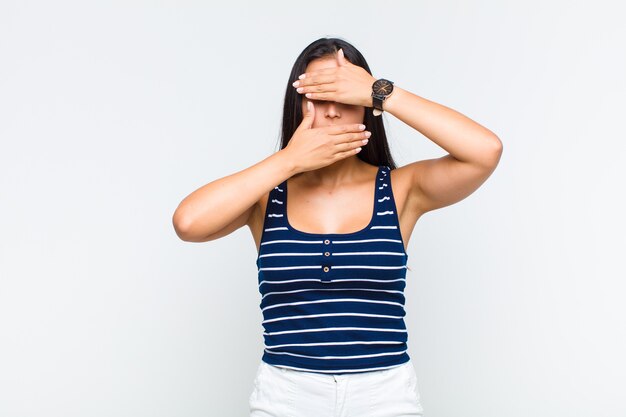 Young woman covering face with both hands