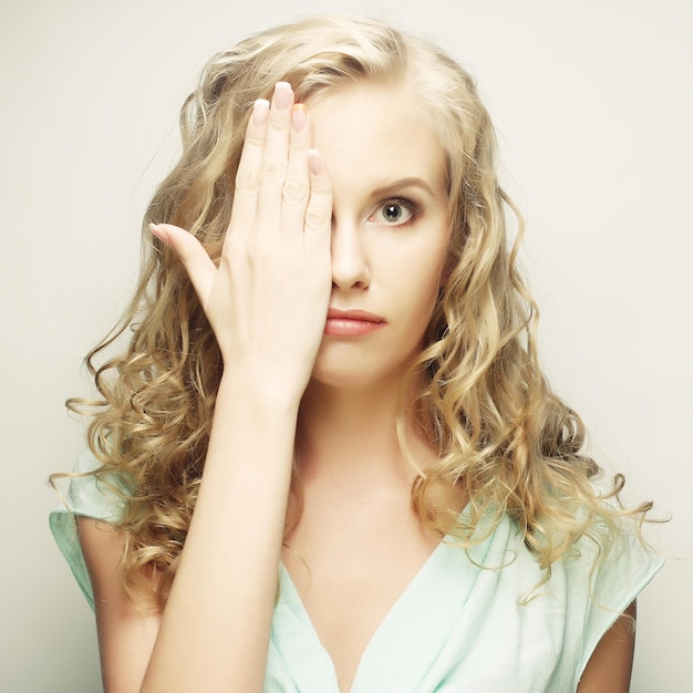 Photo young woman covering her eyes with her hands